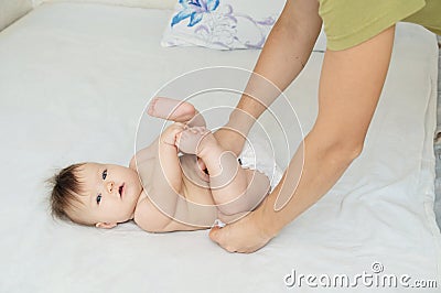 Dad changing diaper on baby girl on bed, changing nappy, everyday care Stock Photo