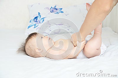 Dad changing diaper on baby girl on bed, changing nappy, everyday life Stock Photo