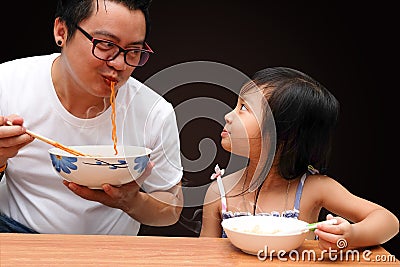 Dad and daughter are eating instant noodles Stock Photo