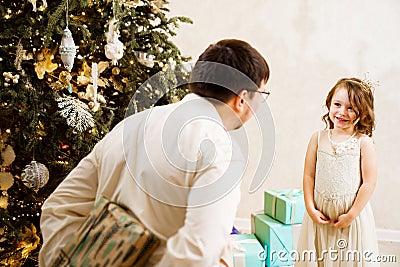 Dad hides behind his back a box with a gift for the baby daughter. Stock Photo