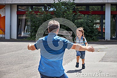 Dad meets a child, a boy from school. The father opens his arms for hugs. Children come home Stock Photo