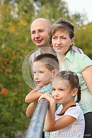 Dad, mom, boy and girl is lean elbow on bridge Stock Photo