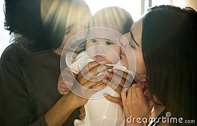 Dad and Mom Kiss Baby Love Emotion Family Stock Photo
