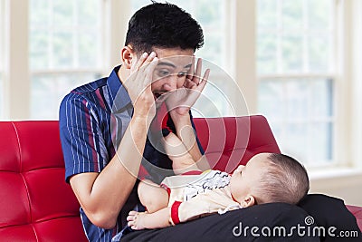 Dad play peekaboo with his baby Stock Photo