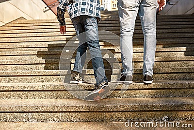 Dad and son with cerebral palsy go up on staircase Stock Photo