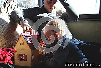 Dad and son are playing in the doll house Stock Photo