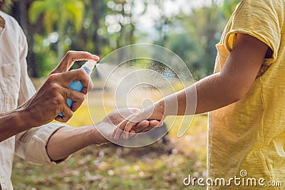 Dad and son use mosquito spray.Spraying insect repellent on skin Stock Photo