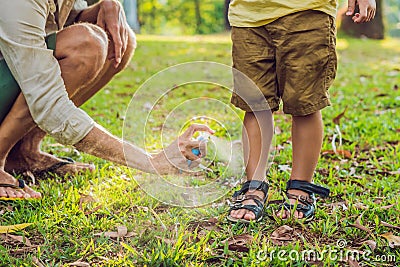 Dad and son use mosquito spray.Spraying insect repellent on skin outdoor Stock Photo