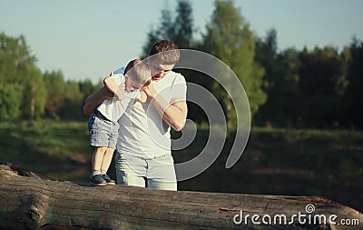 Dad and son walking, father helps child to make baby steps Stock Photo