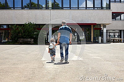 Dad takes the little boy to school or kindergarten. Parents care for their children. Start of the school year, day and lessons Stock Photo