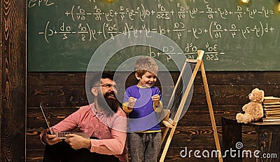 Daddy and kid laughing while learning new things. Smiling teacher and schoolboy having fun together Happy kid at school Stock Photo