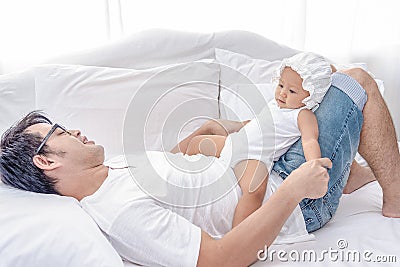 Daddy and little baby daughter tired after playing together. Father takes are of his little girls on the weekend Stock Photo