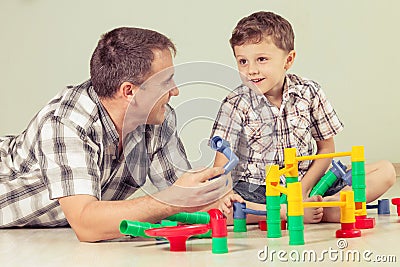 Daddy with little boy playing with toy on the floor at the day Stock Photo