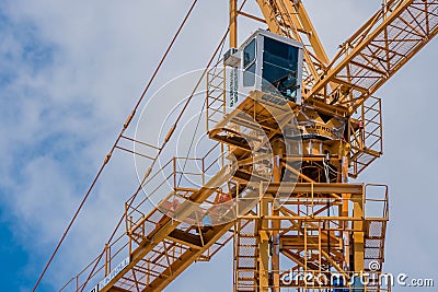 Operator cab on large yellow industrial crane against cloudy sky Editorial Stock Photo