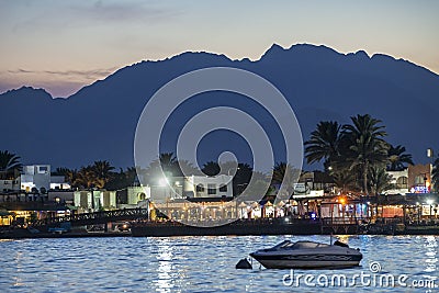 19/11/2018 Dahab, Egypt, incredibly beautiful sunset over a quiet bay in a beautiful spa town with a boat on the foreground Editorial Stock Photo