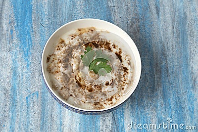 Dahi vada or bhalla. Dahi Bhalla bowl on blue textured background Stock Photo