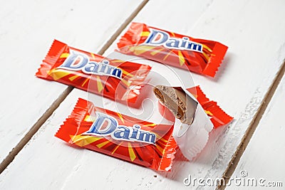 Daim milk chocolate and caramel candy on a wooden table. Editorial Stock Photo