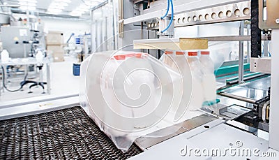 Dairy factory industry, automatic packaging of bottles with milk in plastic bags Stock Photo