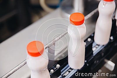 Dairy production, bottle of yoghurt on automated conveyor line, process of milk filling and packaging Stock Photo