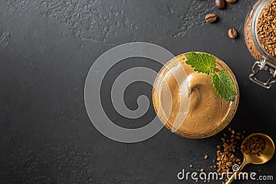 Dalgona frothy coffee in glass on black. Trend korean drink latte espresso with coffee foam. Top view Stock Photo