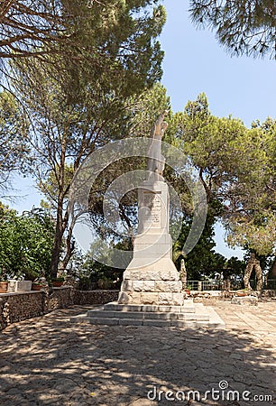 Large stone statue of Elijah - the Prophet stands on a stone pedestal in the garden of the Deir Al-Mukhraqa Carmelite Monastery in Editorial Stock Photo