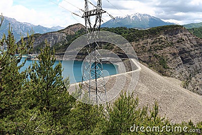 Dam and electricity pole, Lake Serre-Poncon, French Hautes-Alpes Stock Photo