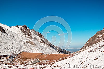 Dam between mountain slopes. Snow mountains and blue skies Stock Photo