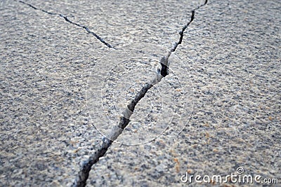 Large crack in a granite slab, with a vanishing perspective. Damage, repair, construction, and infrastructure concepts Stock Photo