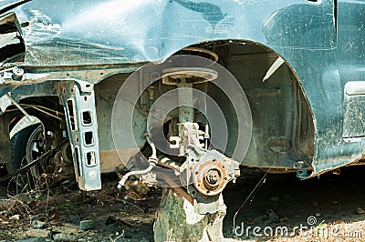 Damaged blue car in crash accident with scratched paint and stolen front wheel. Stock Photo