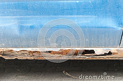 Damaged blue car metal body and scratched paint with rusty corroded parts and hole on the bottom ready for bodywork Stock Photo