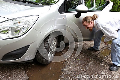 Damaged car of road full of cracked potholes in pavement Stock Photo