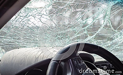 Damaged car window after an accident. Broken windshield as a result of an accident, inside view. Cabin interior details, view from Stock Photo