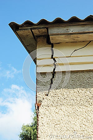 Damaged house stucco wall corner. Cracked Wall near Roof Construction. detail of damaged house corner dilapidated old building Stock Photo