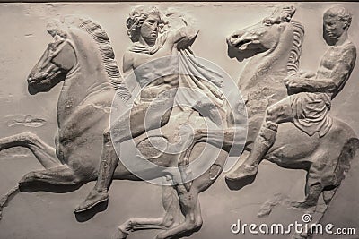 A damaged section of the Elgin Marbles relief originally on the Parthenon in Greece showing two men on horses in a battle Stock Photo