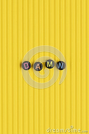 DAMN beads text typography on yellow Stock Photo