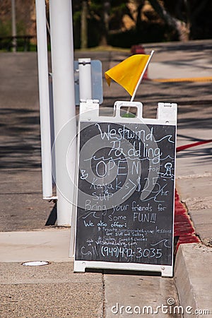 Sandwich board type street sign advertising a paddling and kayak rental business Editorial Stock Photo