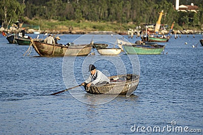 Vietnamese fisherman in a traditional round bamboo boat rowing to makeshift living rafts on the open sea near city of Danang, Editorial Stock Photo