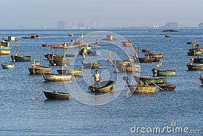 Vietnamese fisherman in a traditional round bamboo boat rowing to makeshift living rafts on the open sea near city of Danang, Editorial Stock Photo