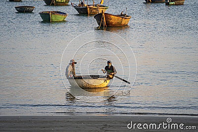 Vietnamese fisherman in a traditional round bamboo boat rowing to makeshift living rafts on the open sea near city of Danang, Editorial Stock Photo