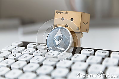 Danbo the box man posing with etherum next to computer keyboard Editorial Stock Photo