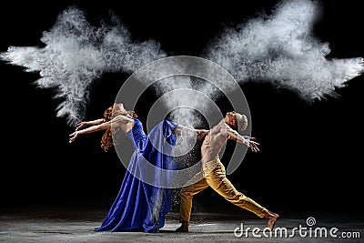 Dance duet with the powder mixtures in the dark. Stock Photo