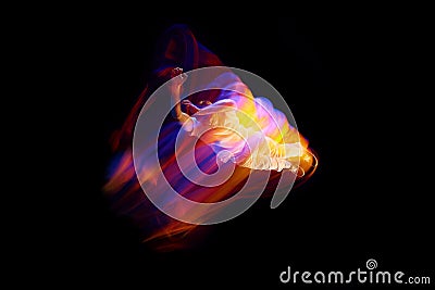 Dance in motion. Studio shot of flying, jumping dancer or gymnast performing tricks in the air over black background Stock Photo