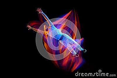 Dance in motion. Studio shot of flying, jumping dancer or gymnast performing tricks in the air over black background Stock Photo