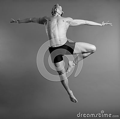 Dancer leaping over gray background Stock Photo