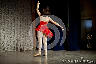 Dancer on stage from the back. Girl in a red dress, white tights and Czechs. Editorial Stock Photo