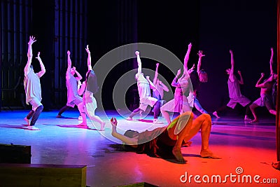Dancers pulling hands up on the stage in red light Editorial Stock Photo
