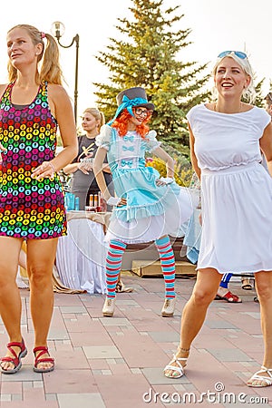 Dancing beautiful and elegant stylish girls participating in the carnival costumed women`s bike ride in the summer evening Editorial Stock Photo