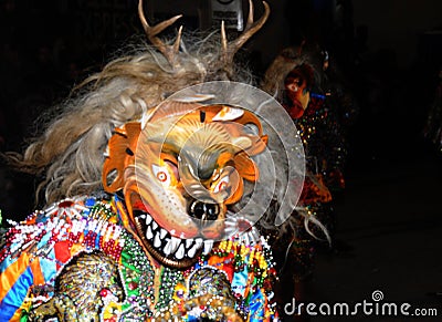 Dancing devotees with devils and demons mask in the streets of the town, the procession of the Virgen del Carmen -. Editorial Stock Photo