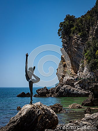 A dancing girl bronze sculpture on the rocky coast in Budva, Montenegro. Editorial Stock Photo