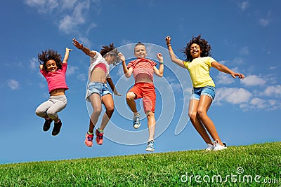 Dancing and jumping group of diverse kids on lawn Stock Photo